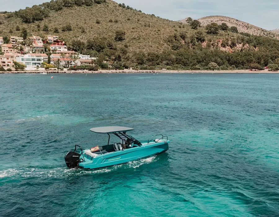 Axopar 22 Spyder on turquoise water near a green hillside