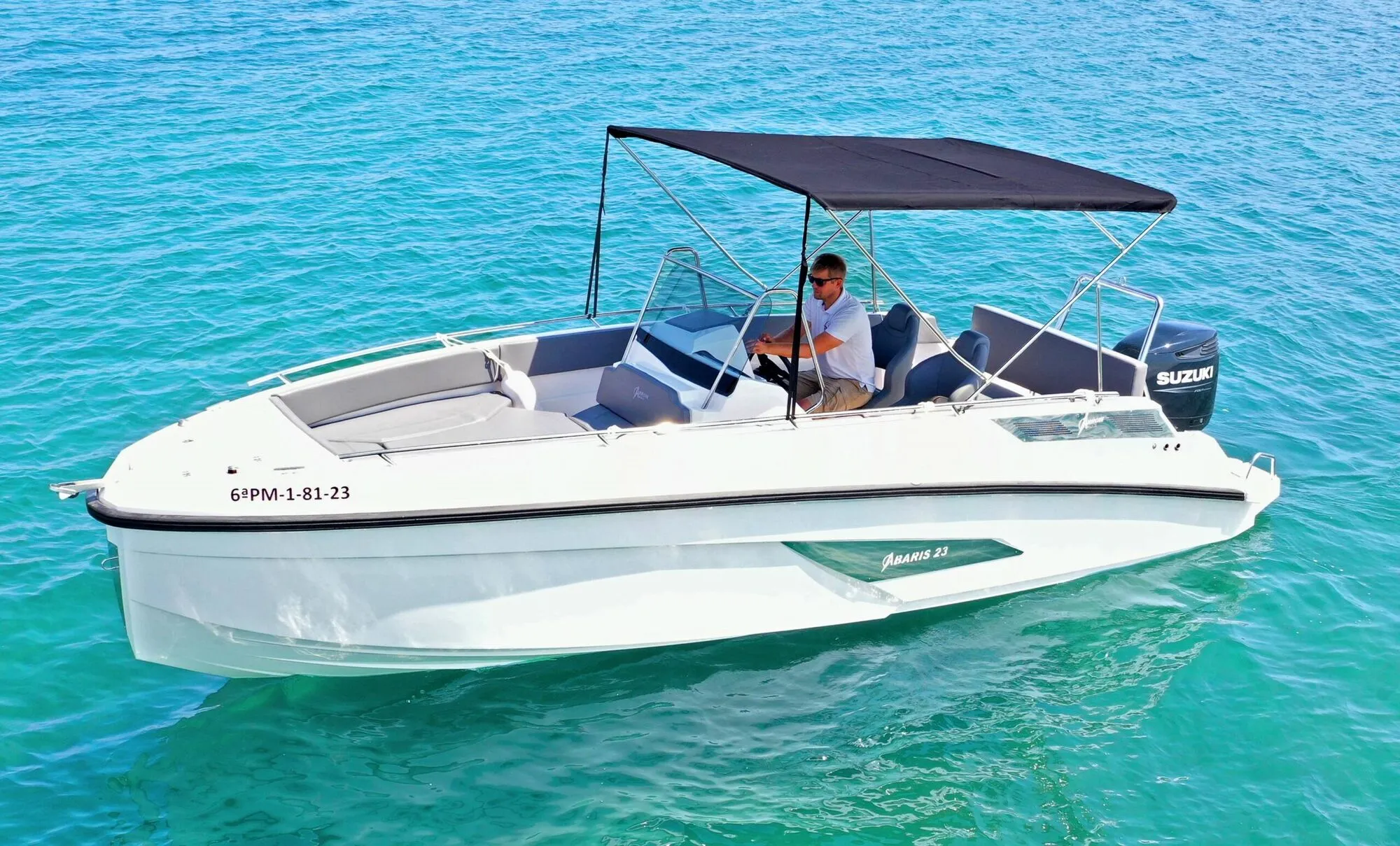 Abaris 23 with the skipper at the helm on turquoise water, seen from above