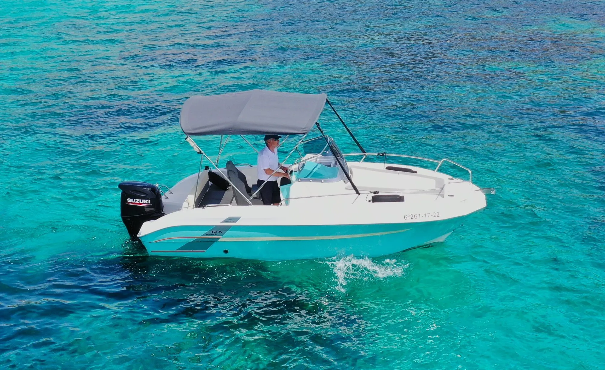 Marine Time 563 on turquoise water with the skipper at the helm