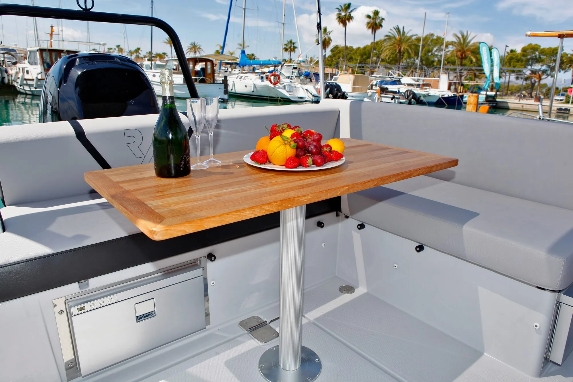 Cockpit table of the Ryck 280 with drinks and fruit, moored in a marina
