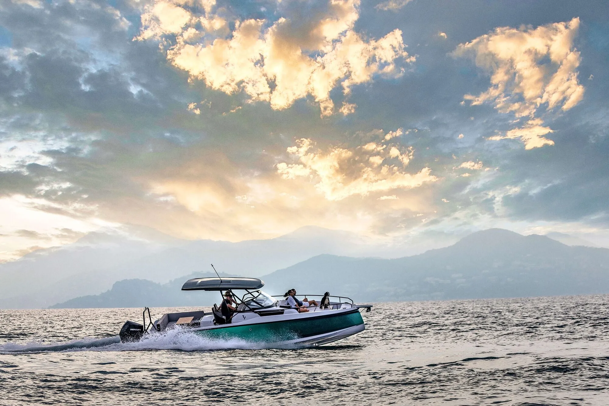 Ryck 280 cruising at sunset with mountains behind