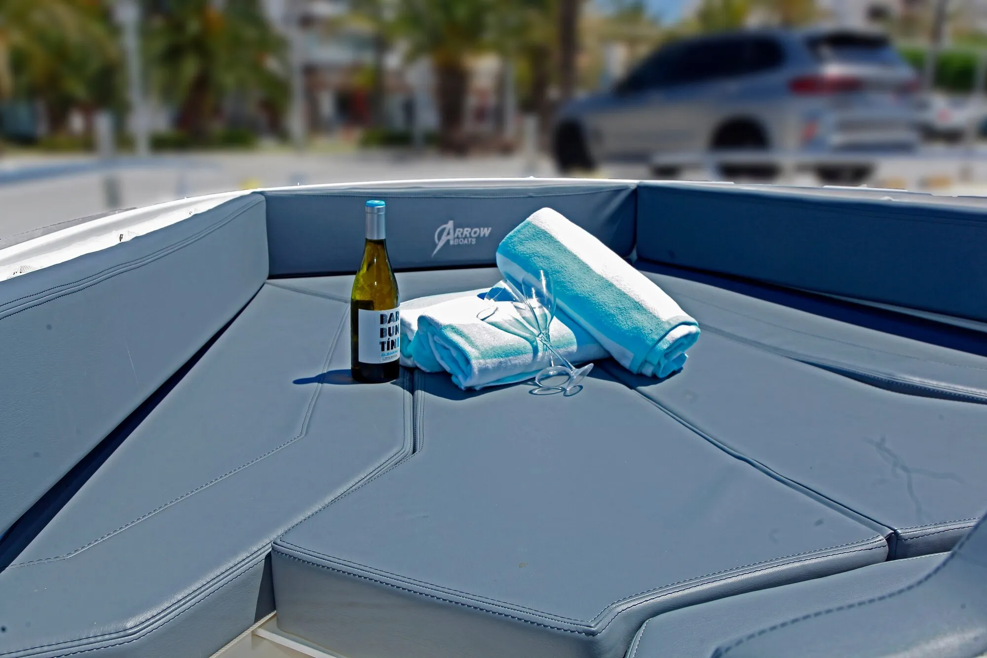 Bow sun pad of the Abaris 23 with towels and a bottle of wine