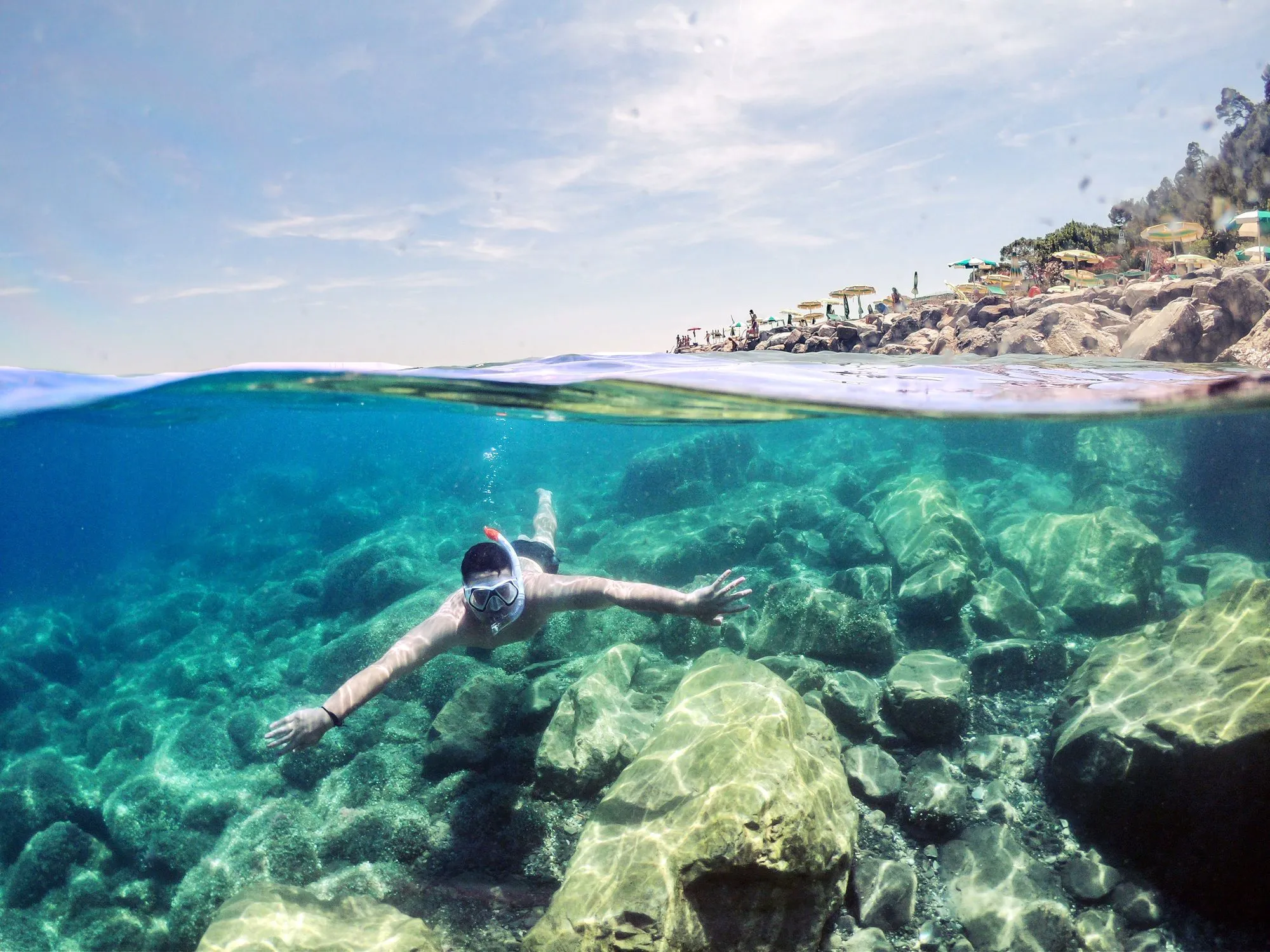 Person snorkelling above a sandy seabed
